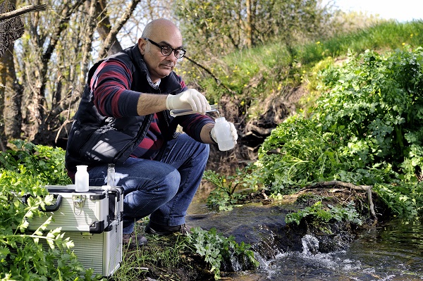 Collecting river water sample for environmental pollution testing